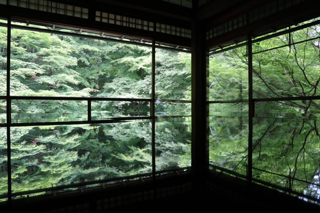 瑠璃光院の机に映る新緑の庭園